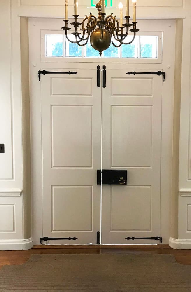 Interior view of double wood doors with a new wood transom overhead