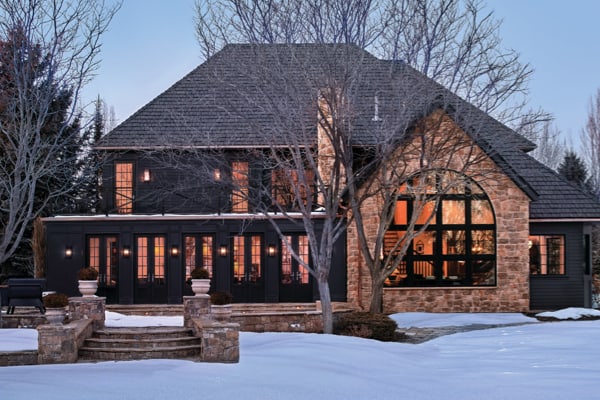 A grand home's front facade with unique shaped windows including an arched window