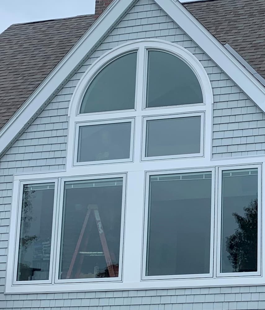 Exterior view of new wood special shape, fixed and casement windows with white trim