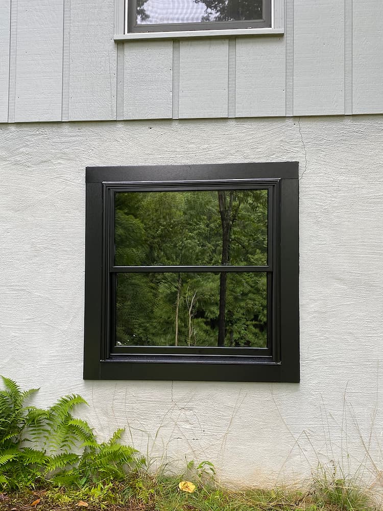 black double-hung window on white exterior of Palmyra home