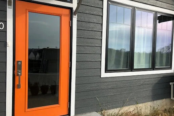 Exterior view of contemporary orange front door from Pella for home in eastern Iowa