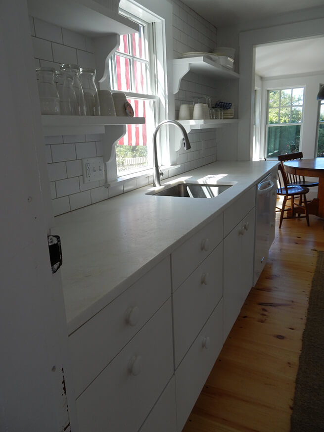 New wood window with white trim above kitchen sink in Cape Cod cottage
