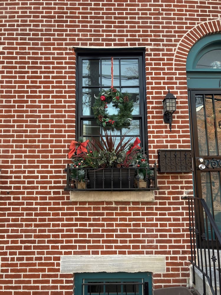 Close up of brick historic building featuring new black wood double-hung windows