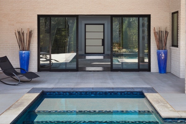 Black multi-slide patio doors open up to pool on back patio