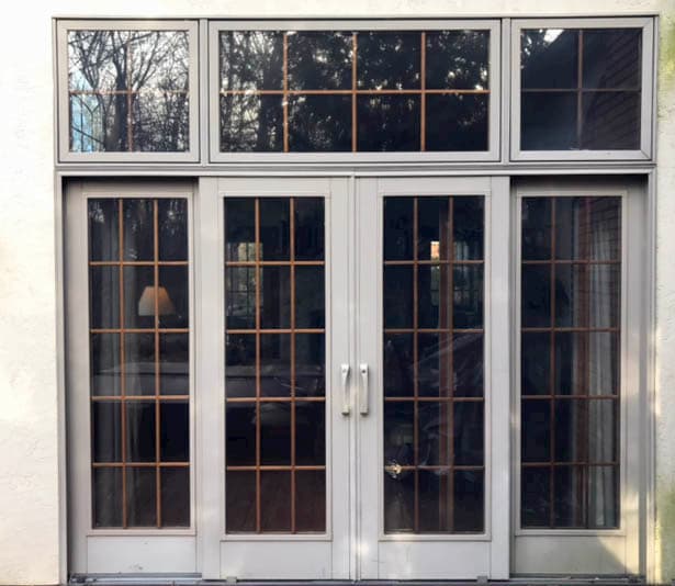 Old double sliding glass patio doors with traditional grille pattern