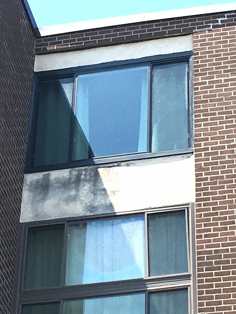 Black fiberglass casement windows on red brick condo building