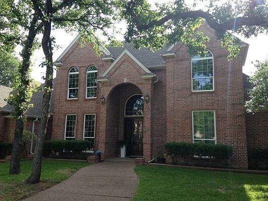 large two story brick home exterior with vaulted entryway