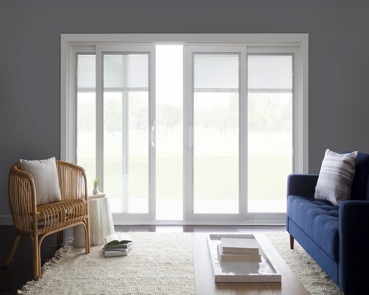 Four-panel sliding patio door partially opened with blinds