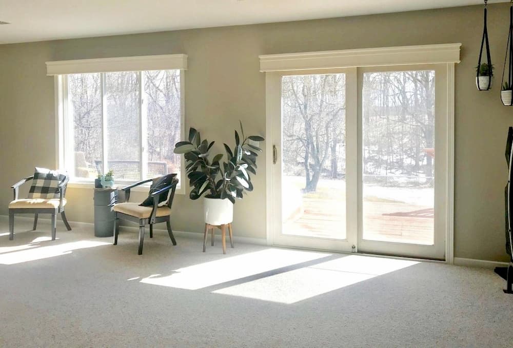 Neutral-colored living room with sliding patio door and casement windows