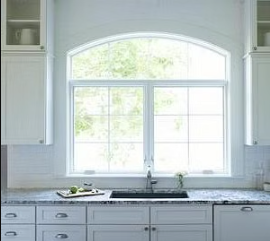 two casement windows with an arched transom over a kitchen counter