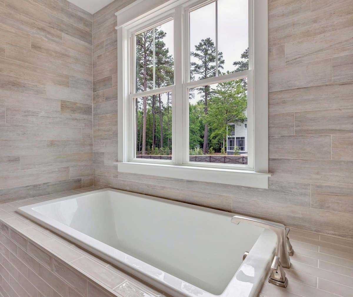 Interior view of two white wood double-hung windows in a bathroom.