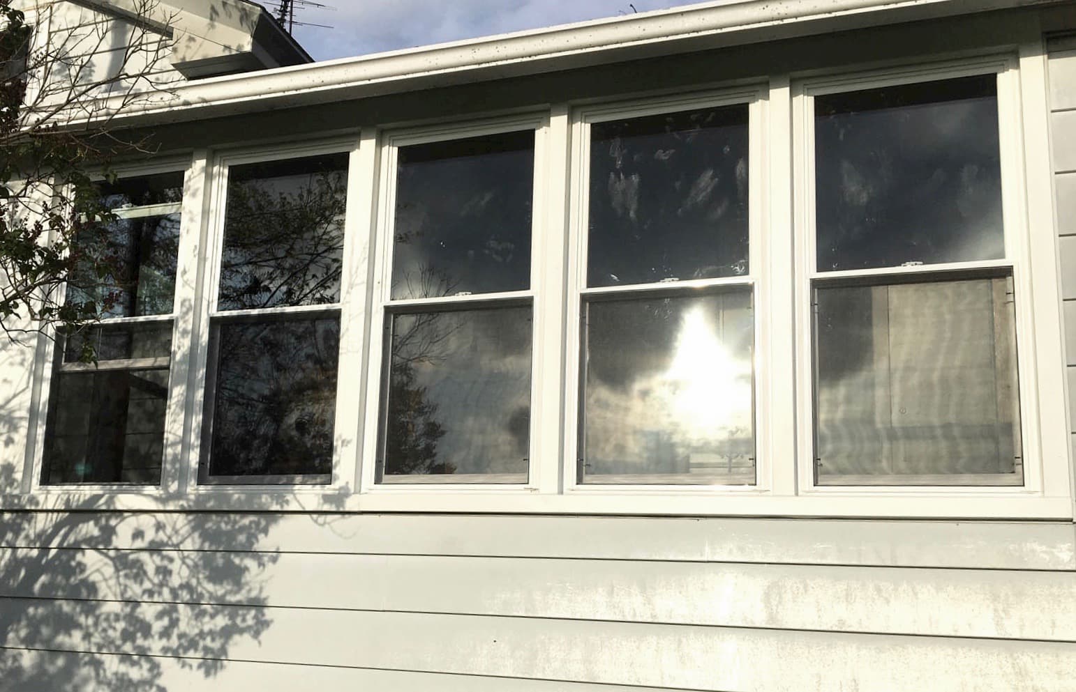 Exterior view of new vinyl double-hung windows on sun porch