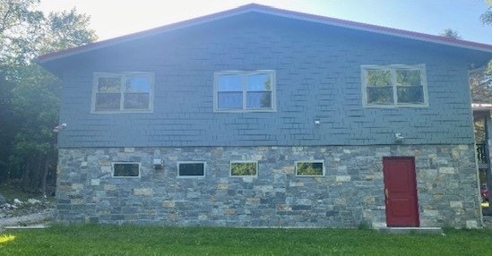 back of home featuring cool-toned siding and stone that matches sky gray window replacements
