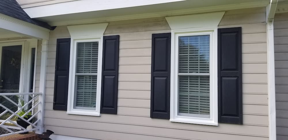 White vinyl double-hung windows with black shutters on exterior of Henrico, VA, home