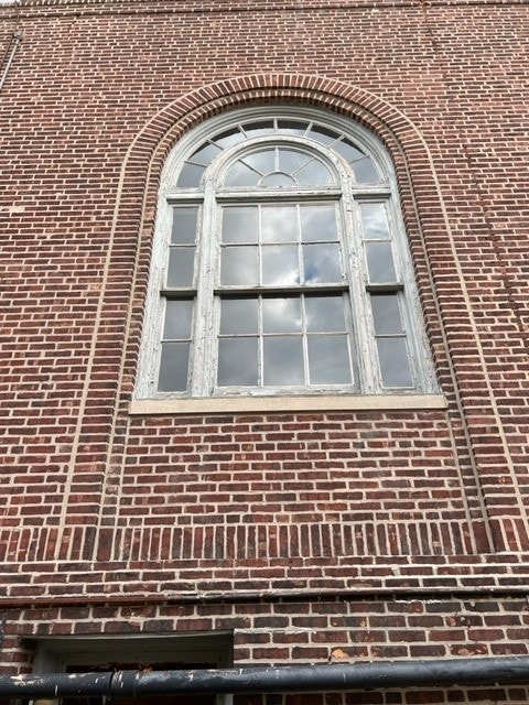 Old, outdated, worn white arched window