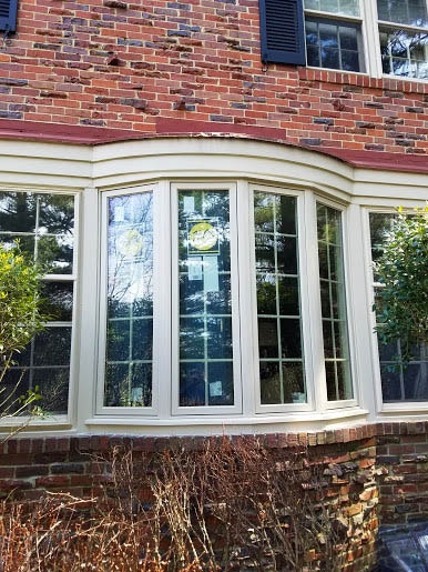 Pella aluminum-clad bow window on a red brick home