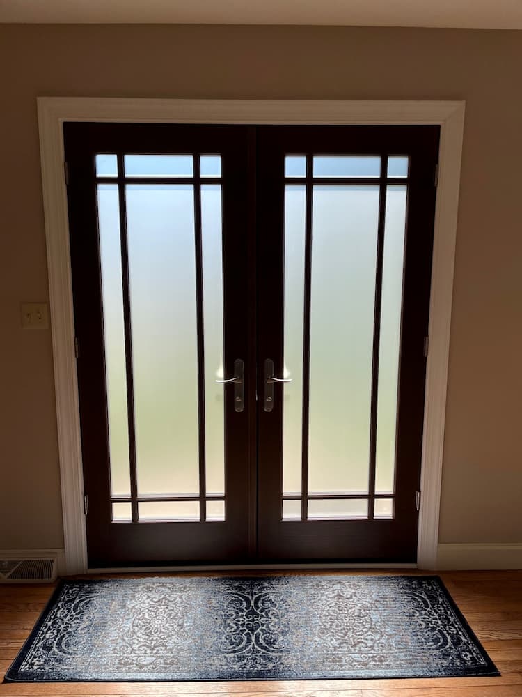 Interior view of double entry door featuring wood stained finish and frosted glass