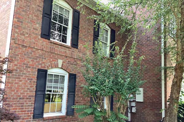 White frame windows with black shutters on brick Brentwood, TN, home