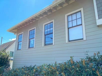 Exterior view of four black wood double-hung windows