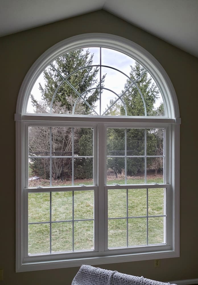 Interior view of two new vinyl double-hung windows topped with an arch window.