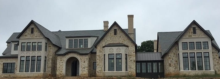 Stone home with windows and arched entryway