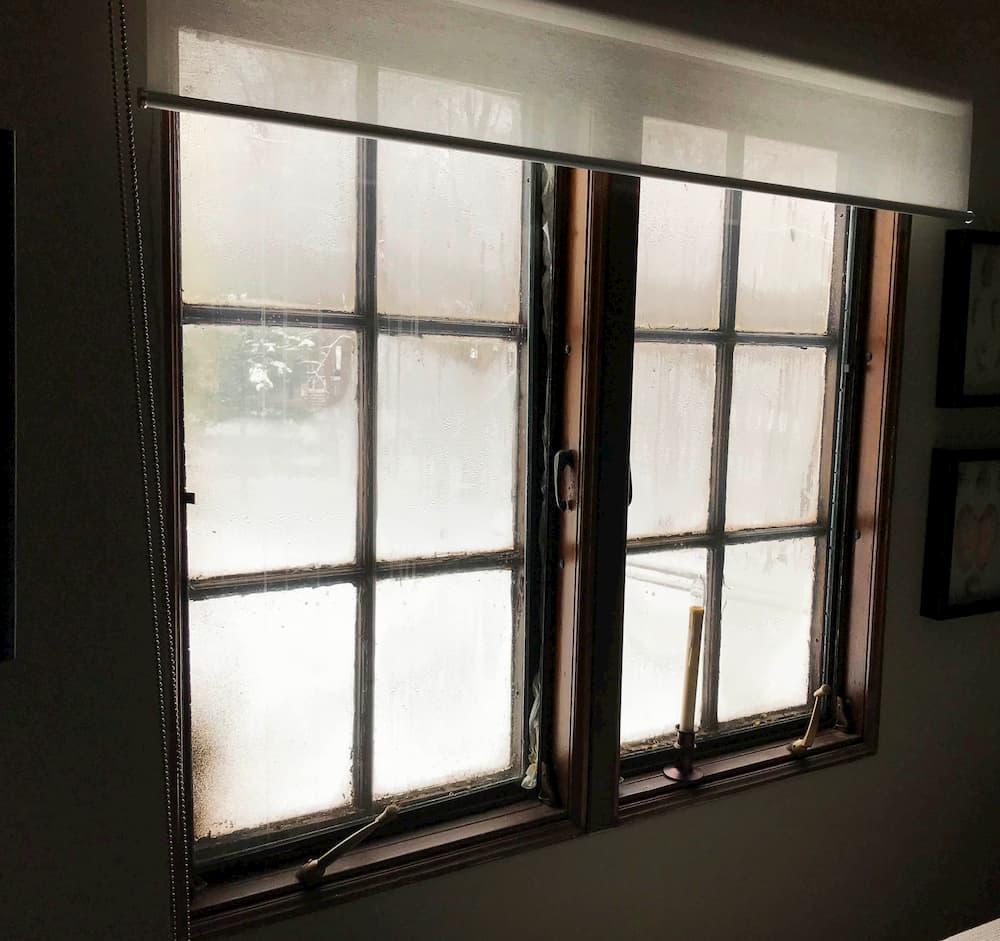 Interior view of two old wood casement windows with traditional grilles