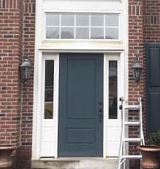 Old solid entry door on a brick home