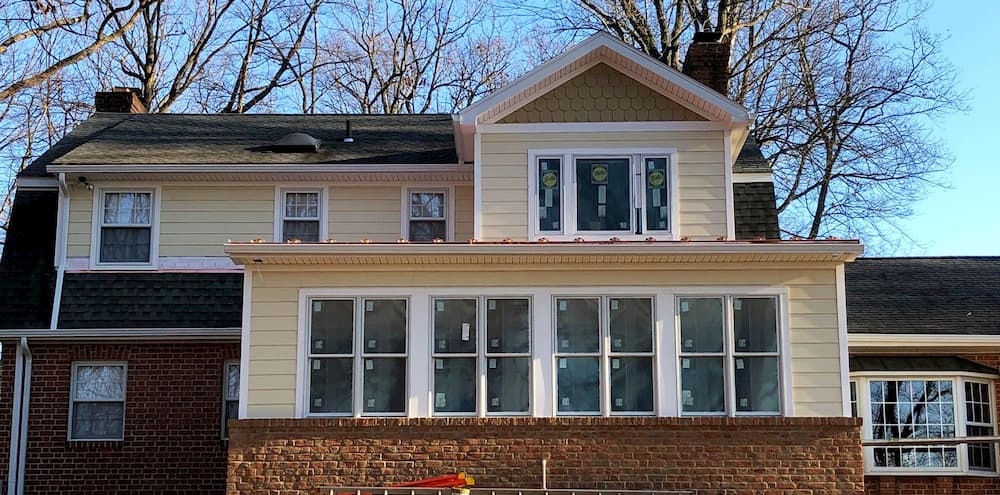 Exterior view of new addition with white wood double-hung windows