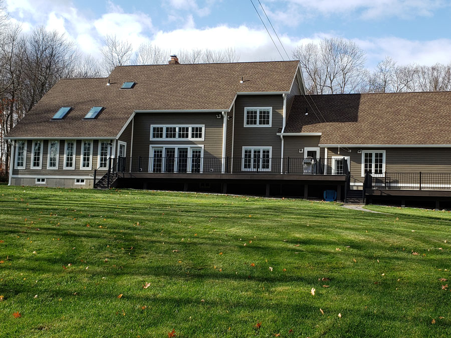 Back exterior view of West Granby, CT, home with new wood windows and a wood patio door
