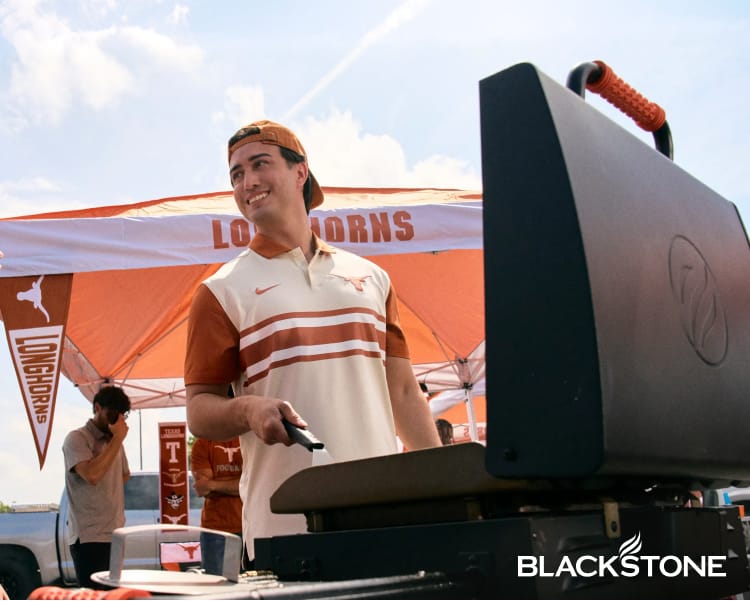 Blackstone 2-burner griddle displayed beside a person cooking outdoors.
