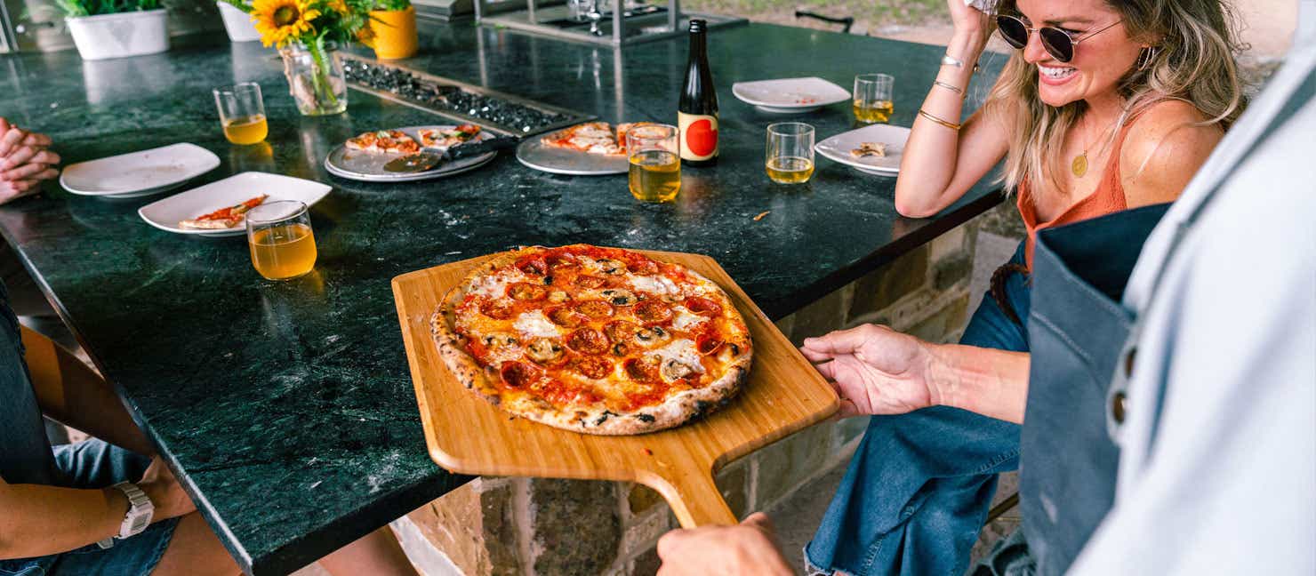 Gathering of friends to enjoy a pizza fresh from the Ooni Pizza Oven