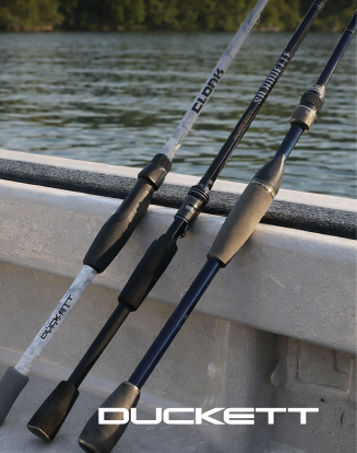 Two Duckett fishing rods resting against the edge of a boat above the water.