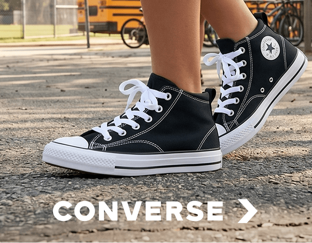 Close-up of black Converse high-top sneakers on pavement. Converse