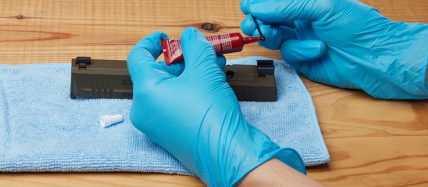 Man inserts screw with thread locker into the hole on the slide
