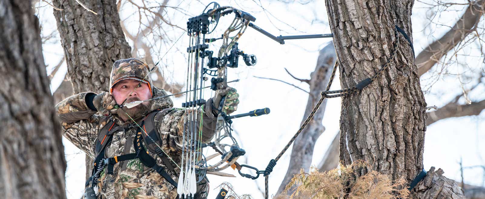 Bowhunter draws back his arrow while aiming for the kill