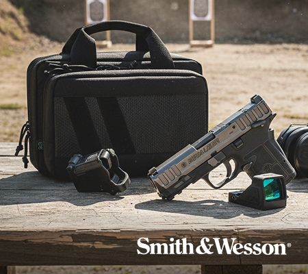Smith & Wesson handgun displayed on a wooden surface outdoors with a black carrying case and accessory nearby.