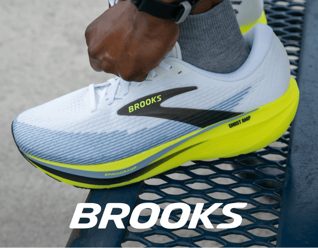 Close-up of a white and gray Brooks running shoe with green accents.