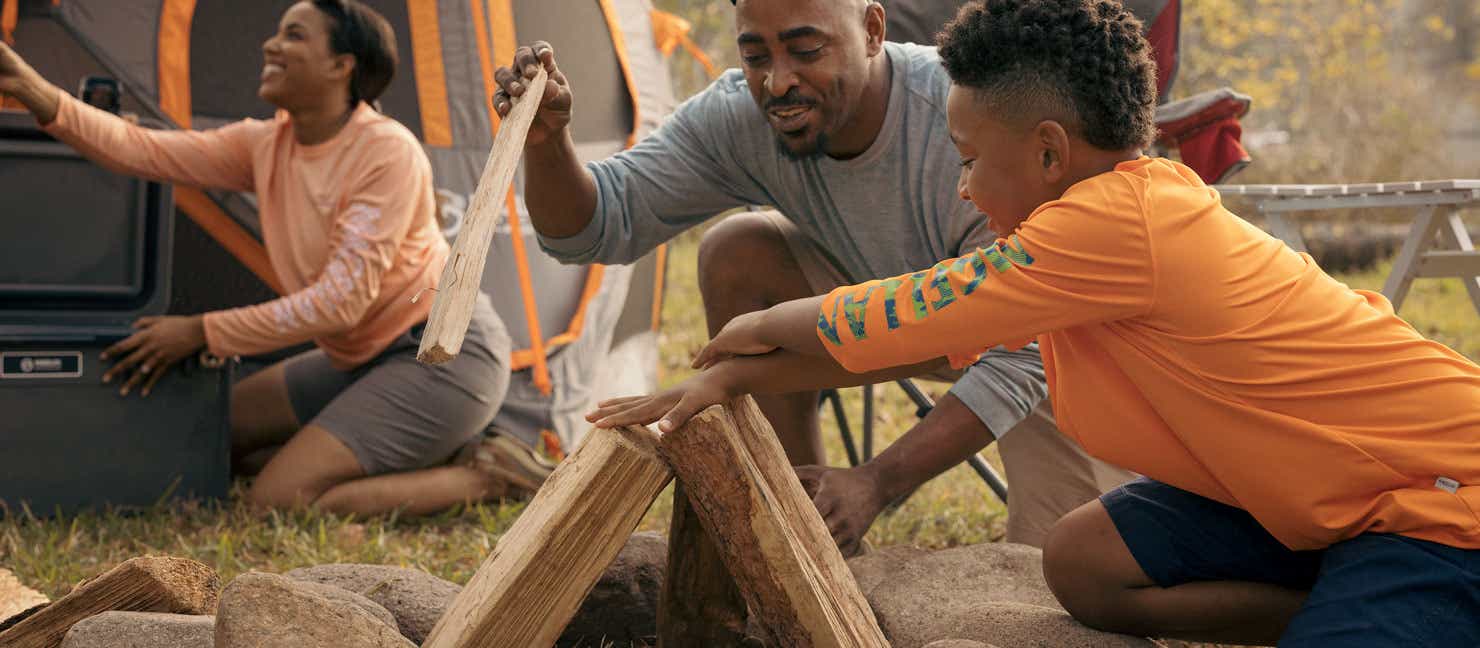 Family building a fire for camping trip