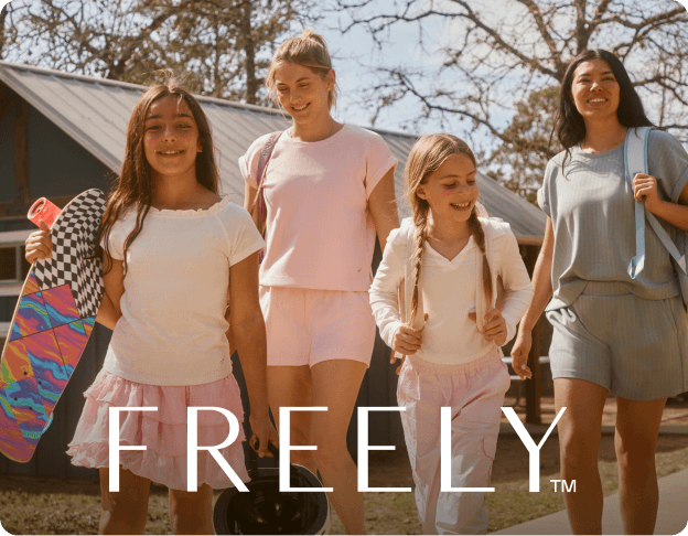 Group of people walking outdoors wearing FREELY apparel. FREELY