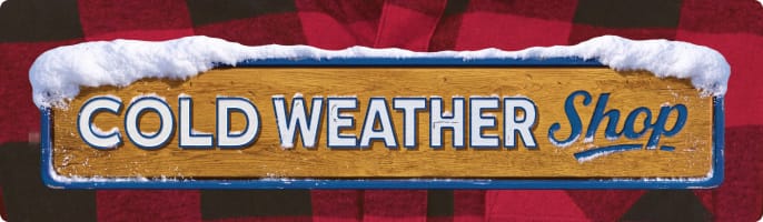Wooden sign reading: Cold Weather Shop topped with snow displayed against a red and black plaid fabric background.