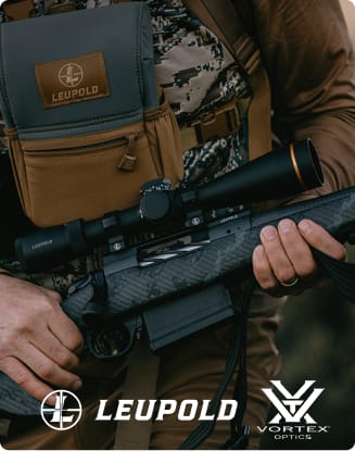 Close-up of a hunter carrying a rifle with a mounted Leupold scope and a chest-worn optics pouch.
