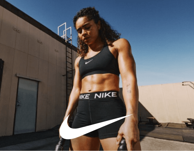 Female athlete in black Nike tennis outfit holding racket on court.