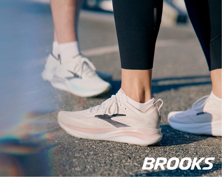 Close-up of Brooks Adrenaline GTS 26 running shoes being worn during an outdoor walk or run on a paved surface.