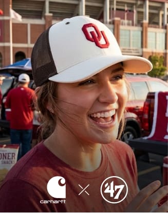 Person wearing an Oklahoma Sooners baseball cap near a tailgating area. Features ’47 brand logo.