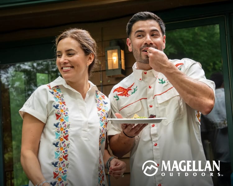 Two people wearing embroidered short-sleeve shirts from the Magellan Outdoors Hispanic Heritage collection while standing outdoors.