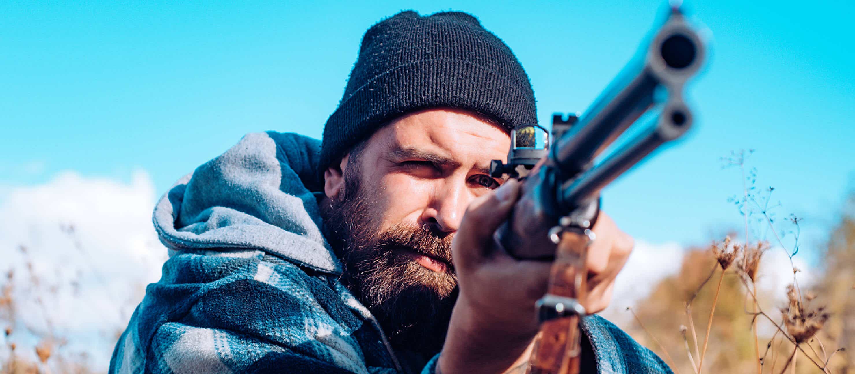 man holding a shotgun on a hunt