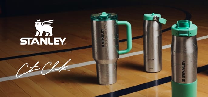 Stanley drinkware collection displayed on a hardwood basketball court, featuring a large handled tumbler, a slim bottle, and a water bottle in stainless steel with mint green accents. White overlay logo for Stanley x Caitlin Clark.