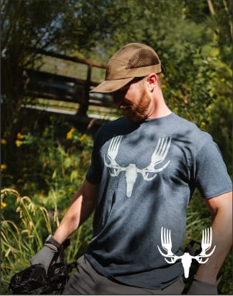 Person outdoors wearing a MeatEater graphic T-shirt. Text promotes featured apparel as seen on MeatEater.