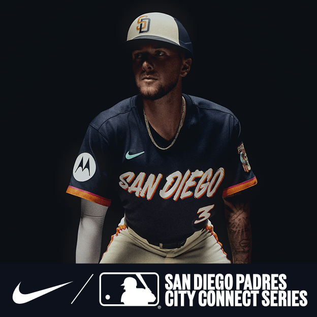 Professional baseball player wearing a navy San Diego Padres City Connect jersey and cap in dramatic studio lighting.