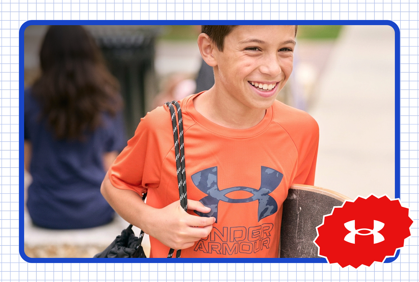 Student wearing an orange Under Armour shirt and carrying a skateboard at school.